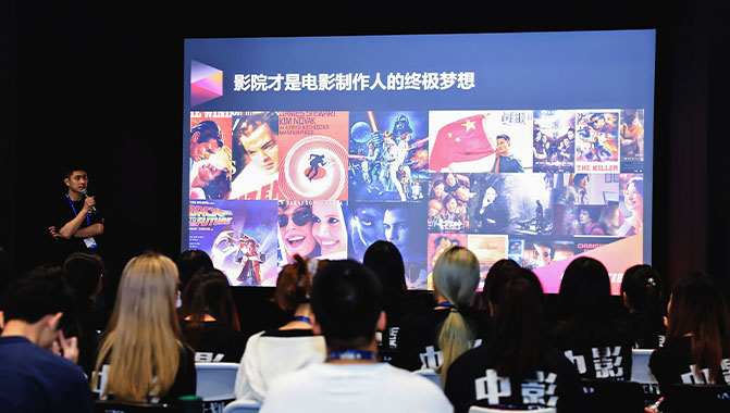 A male speaker presenting to an audience, engaging them with his speech and captivating their attention.