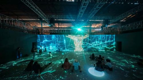 An immersive rooom with projection mapped designs on a large screen