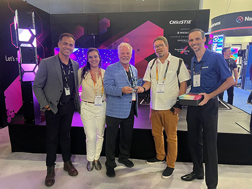 5 people standing togther in front of the Christie booth at Infocomm 2024