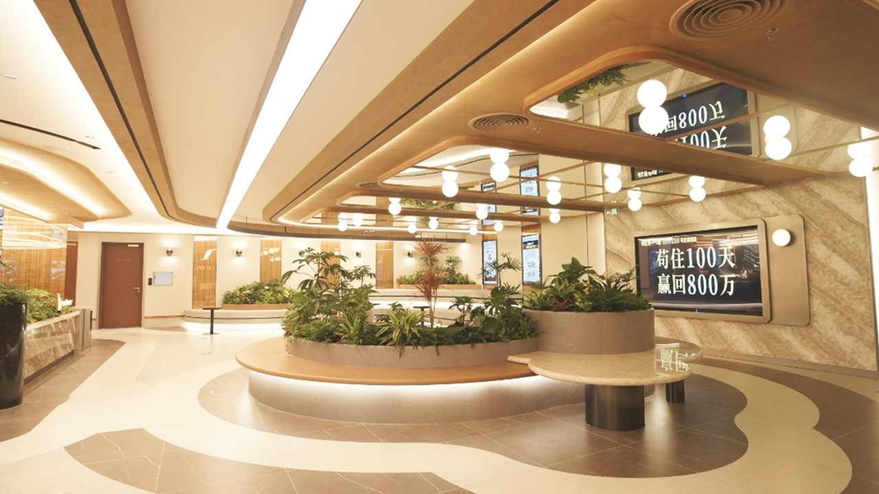 A contemporary cinema lobby featuring a large screen and decorative plants, creating a welcoming atmosphere.