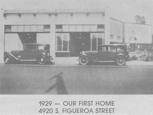 Street view of a business front with 2 cars parked out front.