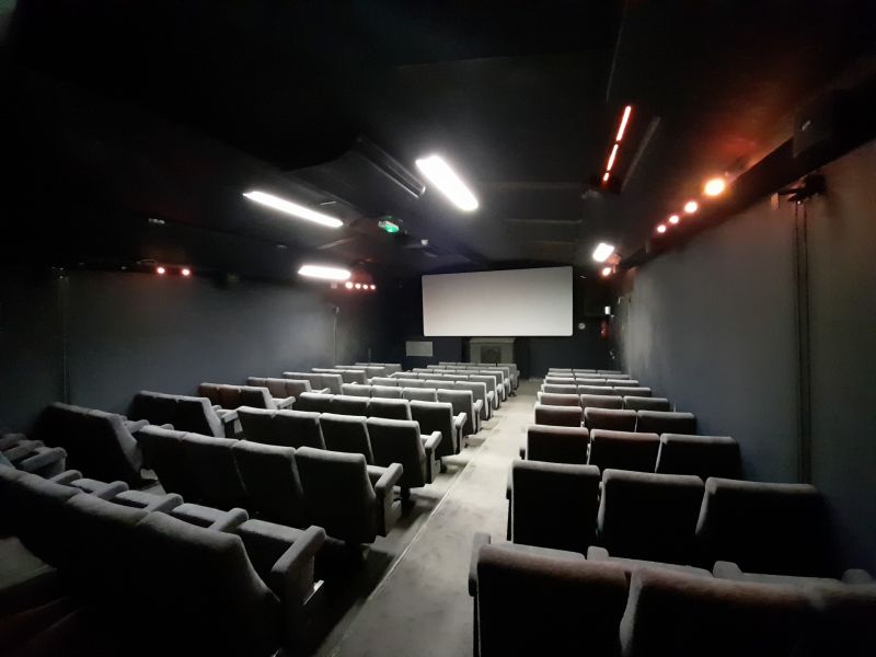 A narrow, empty movie theatre.