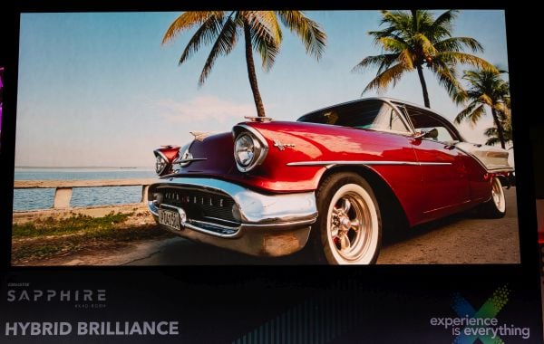 A large screen with a projected image of a red car.